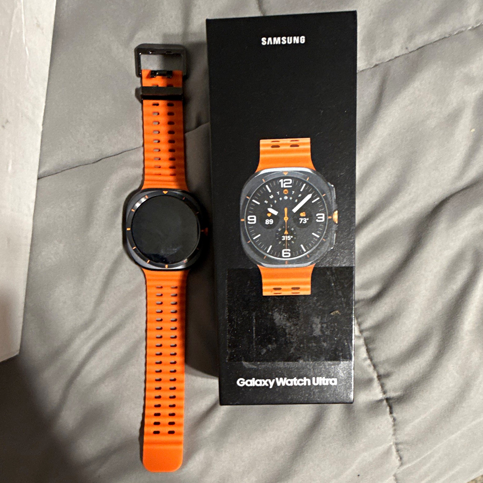 Samsung Galaxy Watch Ultra 47mm Titanium Black Case, Orange Silicone Ban/ lte